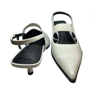 White pointed toe mule kitten heels with ankle strap.